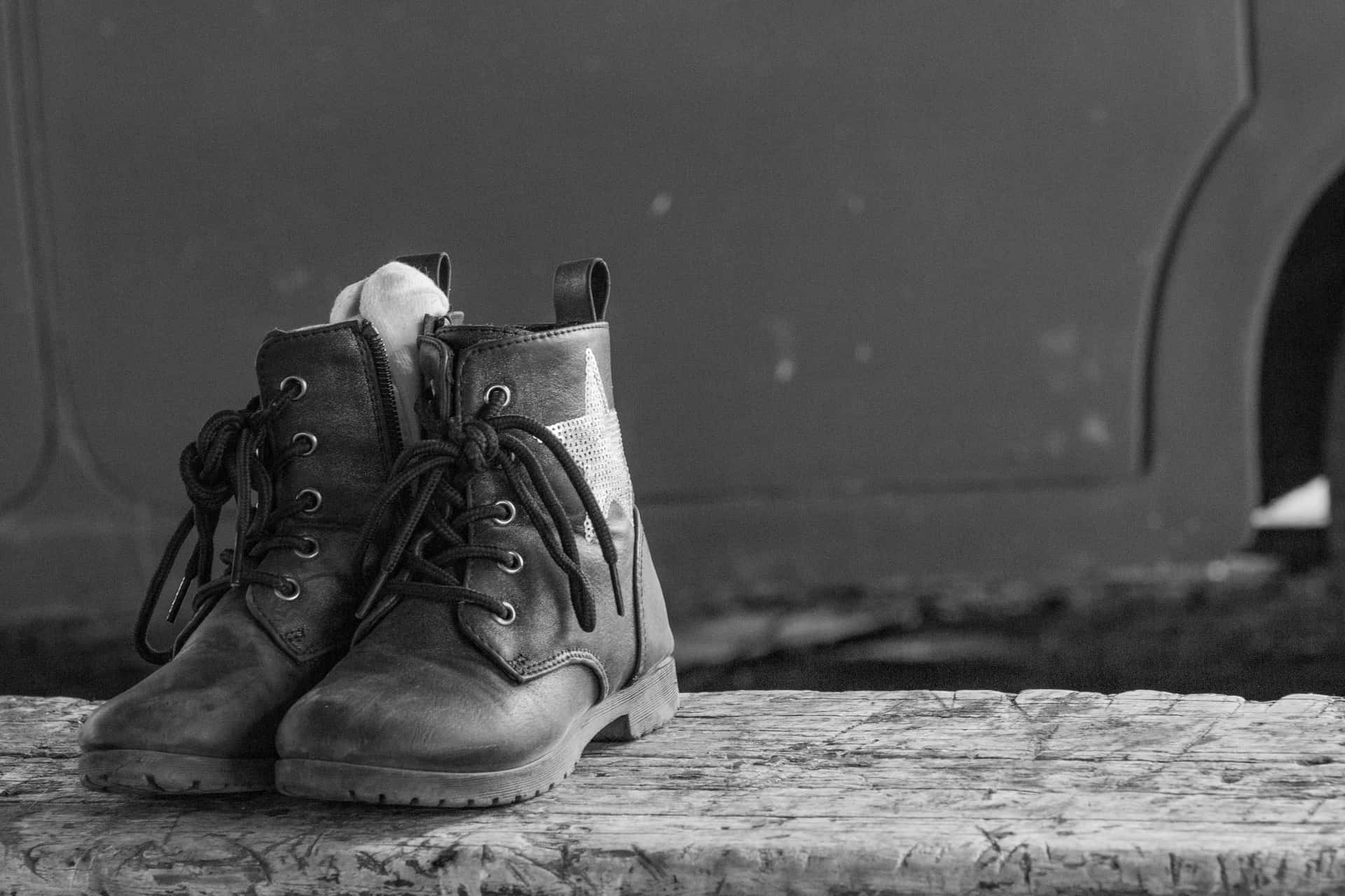 A row of leather work boots lined up on a wooden bench
