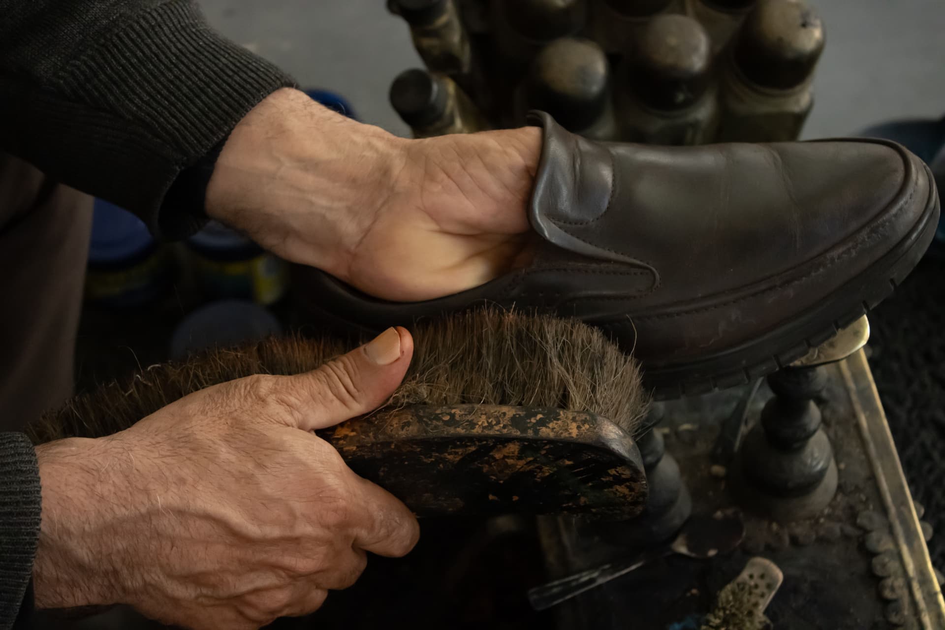 Leather boots being cleaned and conditioned with a cloth