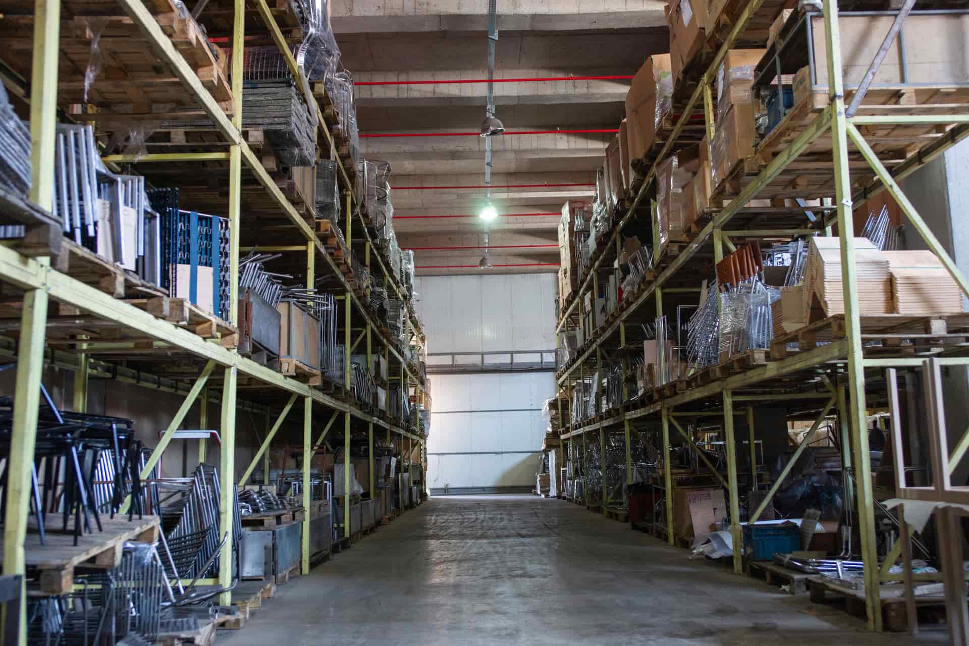 A long warehouse aisle lined with racking and pallets