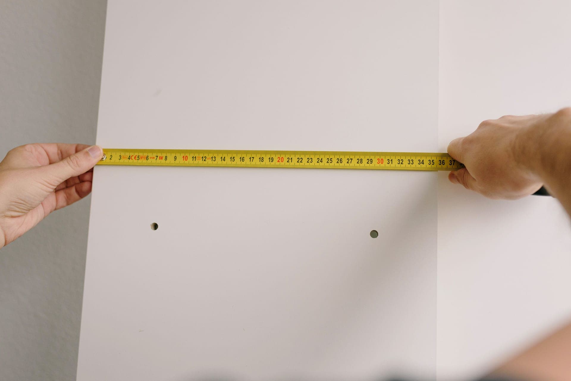 A bare foot measured against a boot sole for width